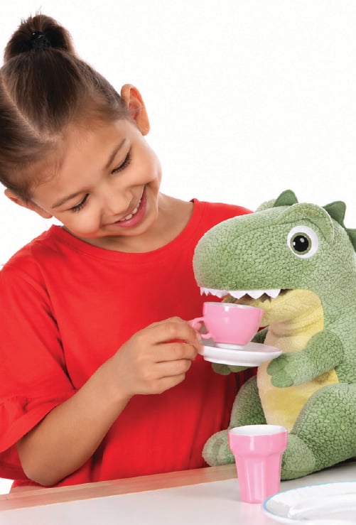 young girl holding teacup up to toy dinosaur