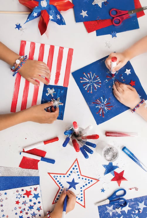 overhead shot of a hands working on patriotic-themed arts and crafts
