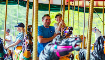 people riding a carousel people riding a carousel