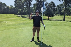 a male golfer holding up a ball