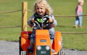 kid on pedal tractor