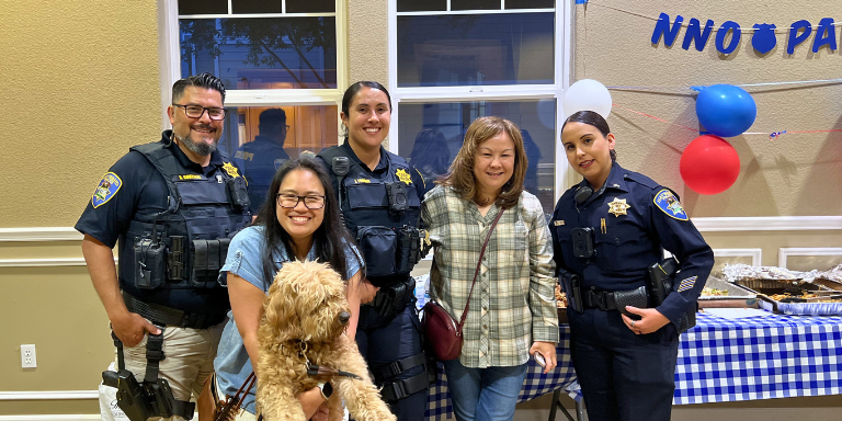 Photo of police officers and community members with a dog posing for a group photo during the 2025 National Night Out event. Photo of police officers and community members with a dog posing for a group photo during the 2025 National Night Out event.