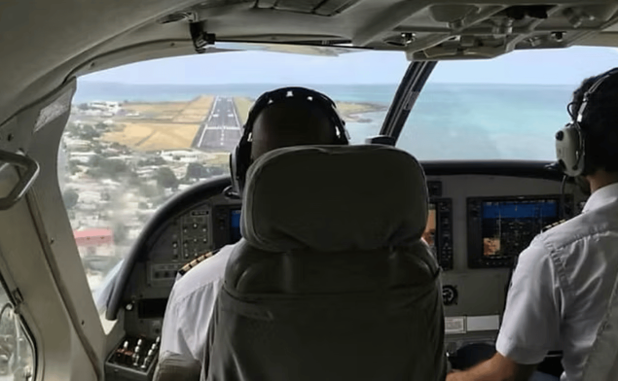 Pilots view a runway and coastline from an aircraft cockpit Pilots view a runway and coastline from an aircraft cockpit