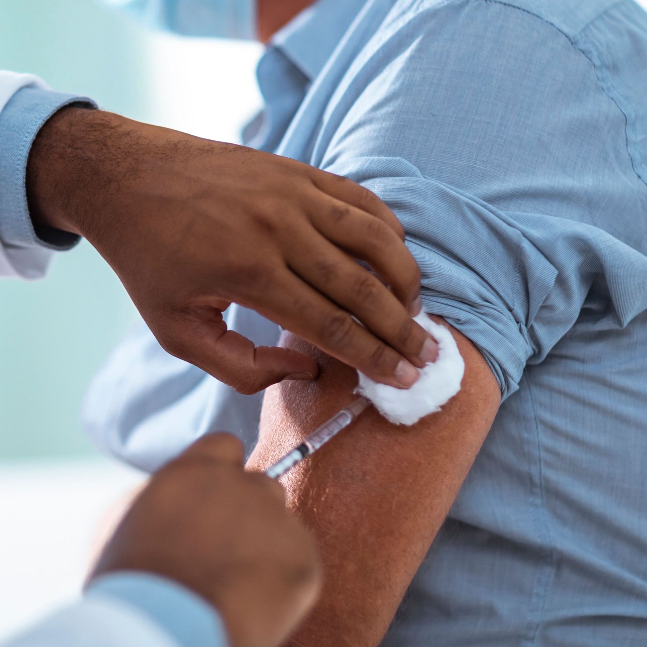 Un hombre recibiendo la vacuna contra la gripe