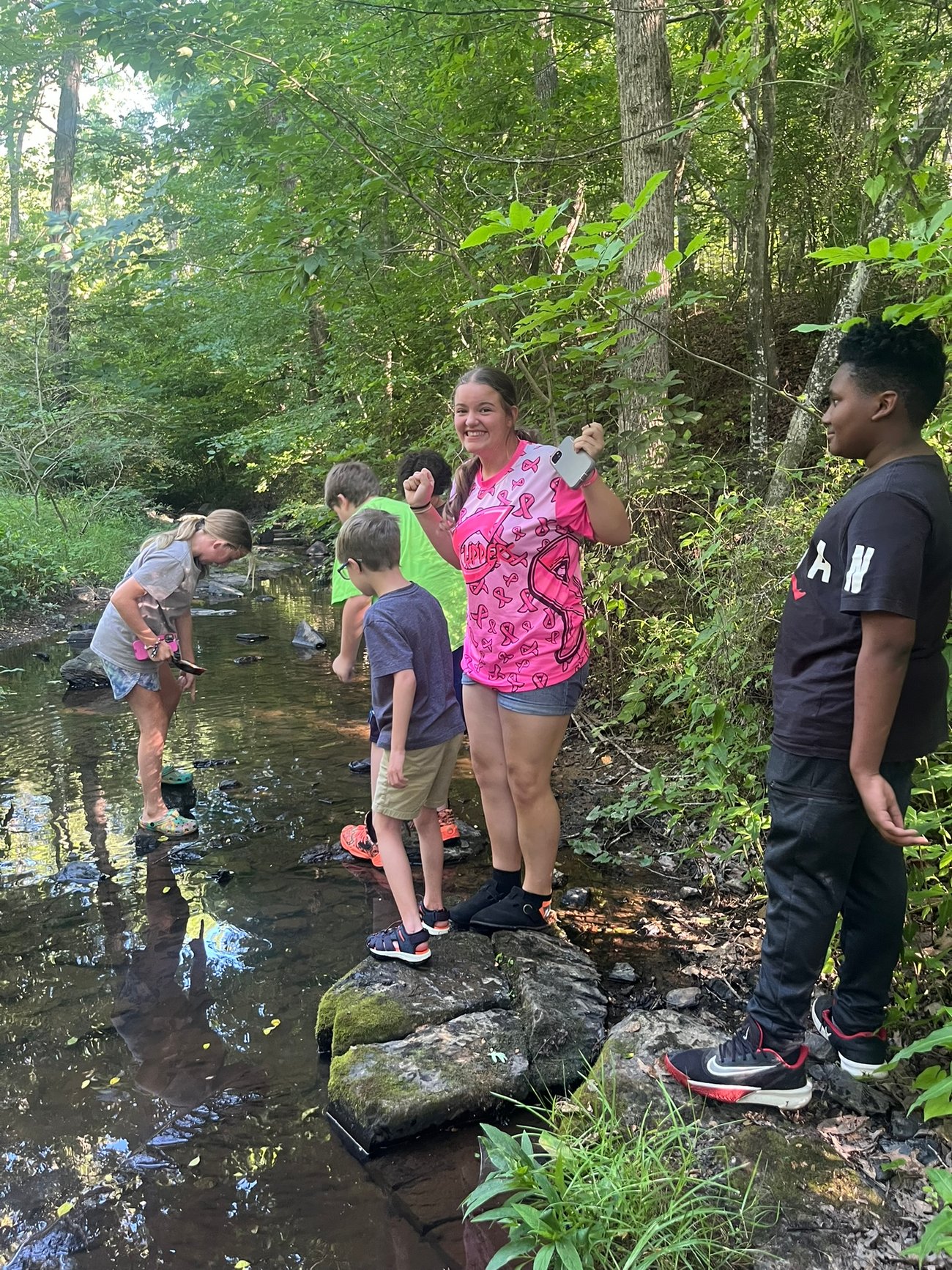 Kids picking up trash in a creek