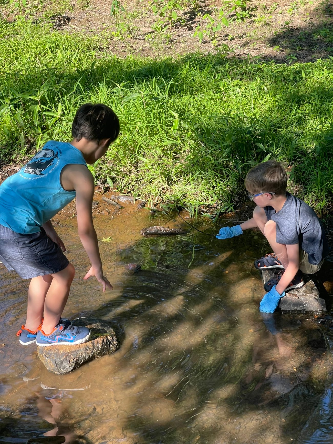 Kids cleaning up trash in a creek