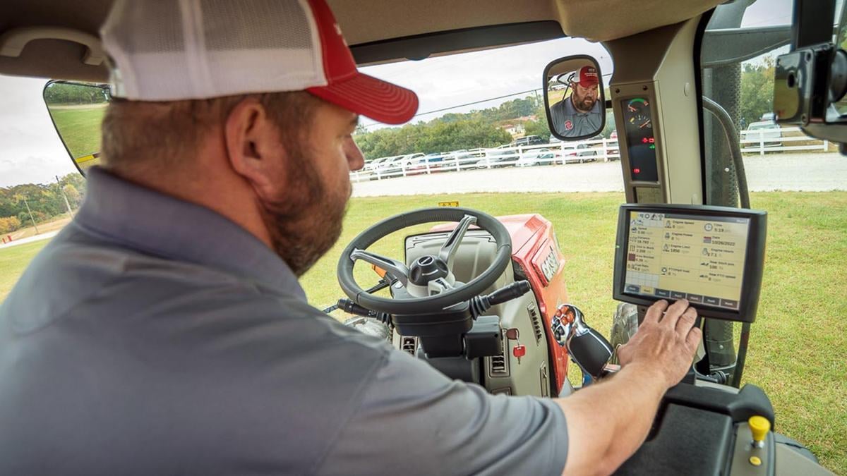 An NC State Extension cybersecurity expert uses a touchscreen inside a tractor cab.