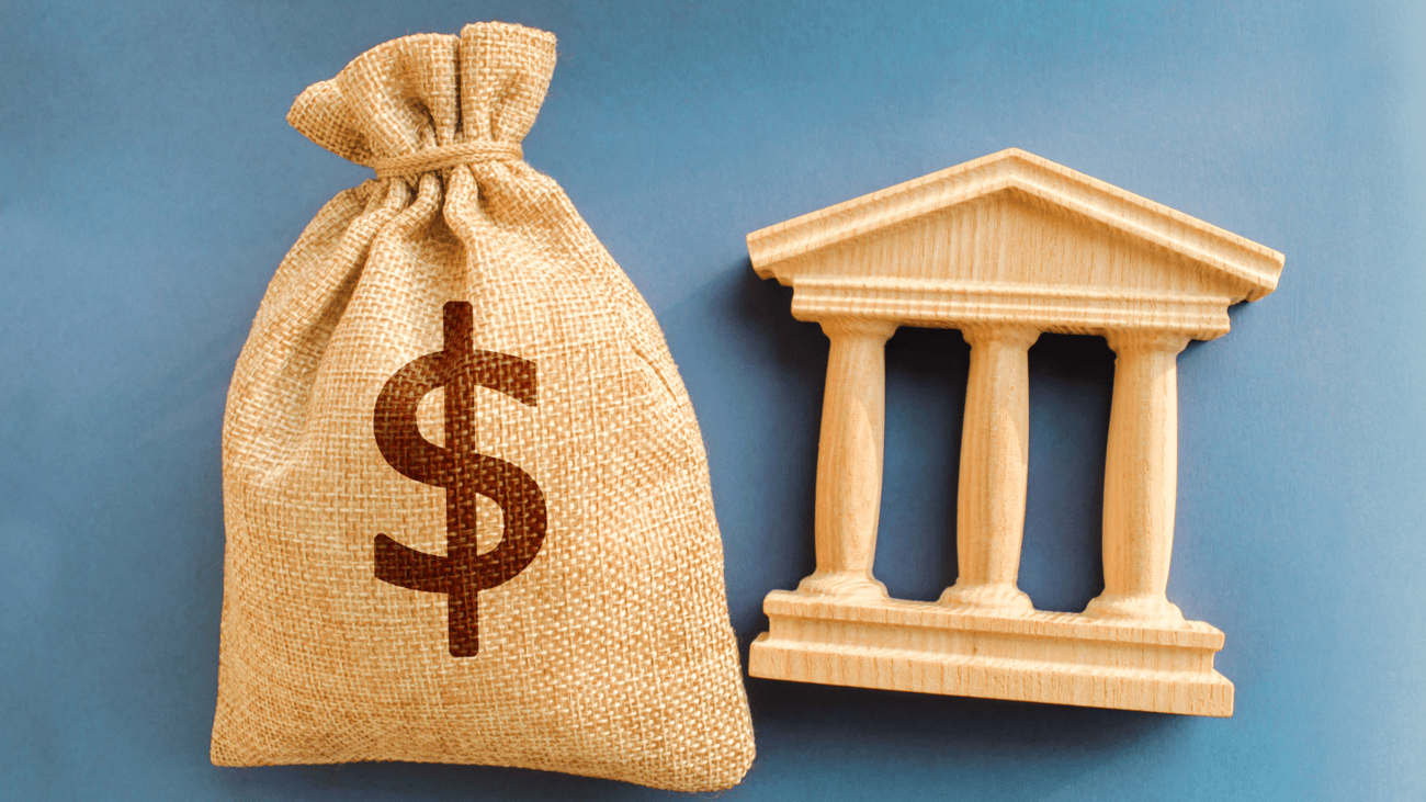 Header image of money bag and pillars carved out of wood