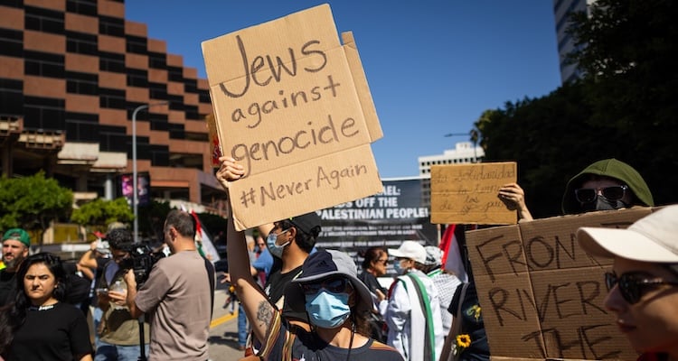 Crowd holding handwritten signs at a public protest