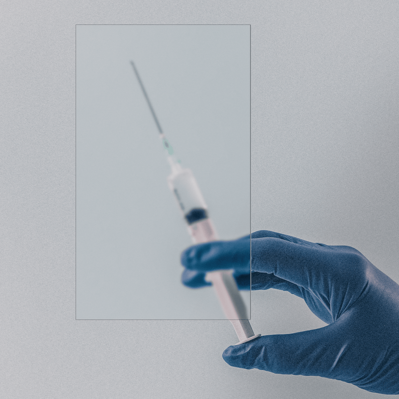 A gloved hand holds a syringe against a pale blue background