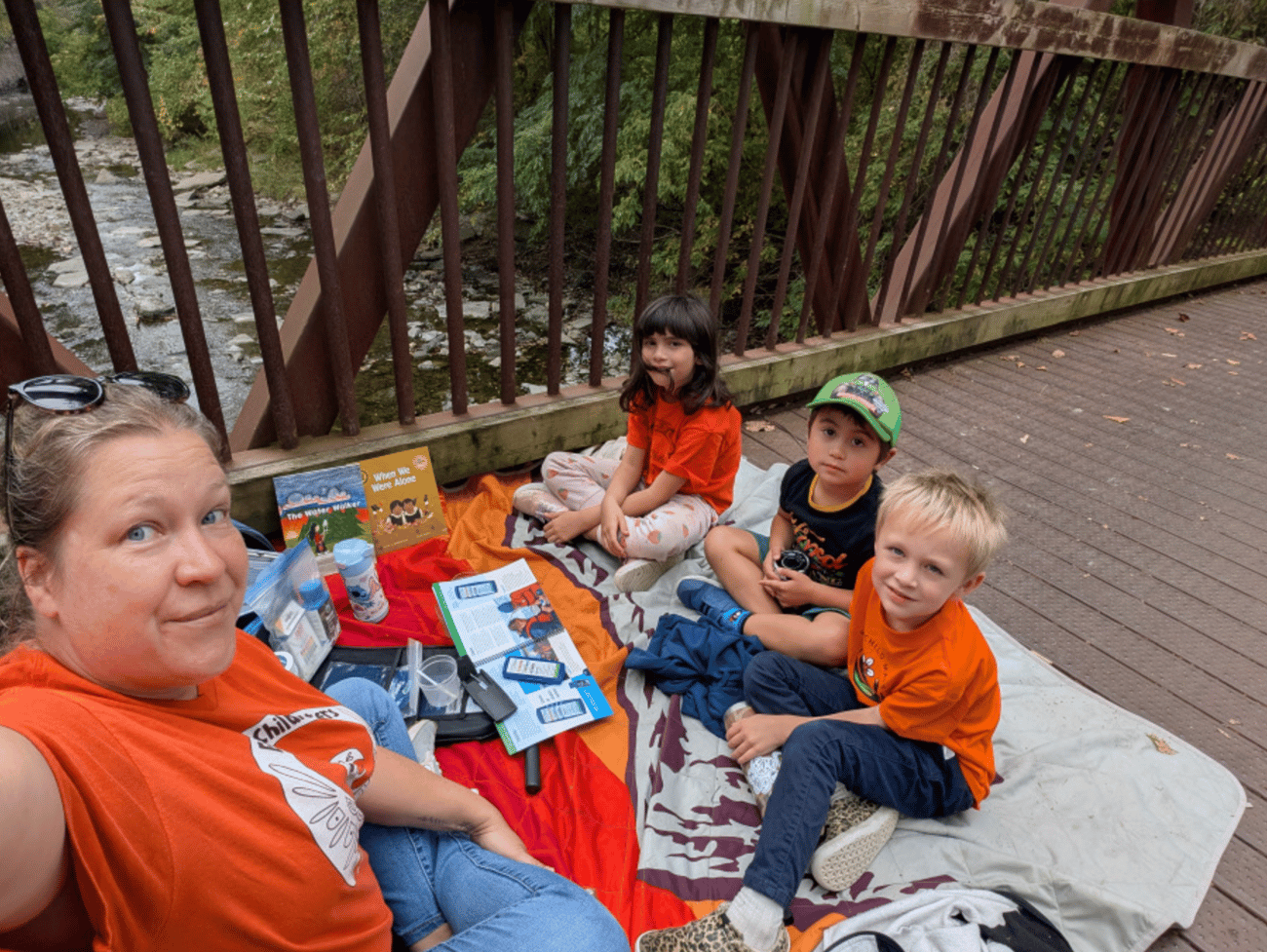 Children Sitting at bridge learning about water Children Sitting at bridge learning about water