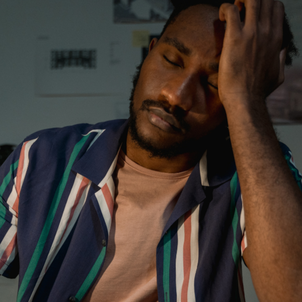 Man with his eyes closed leaning his head on his head