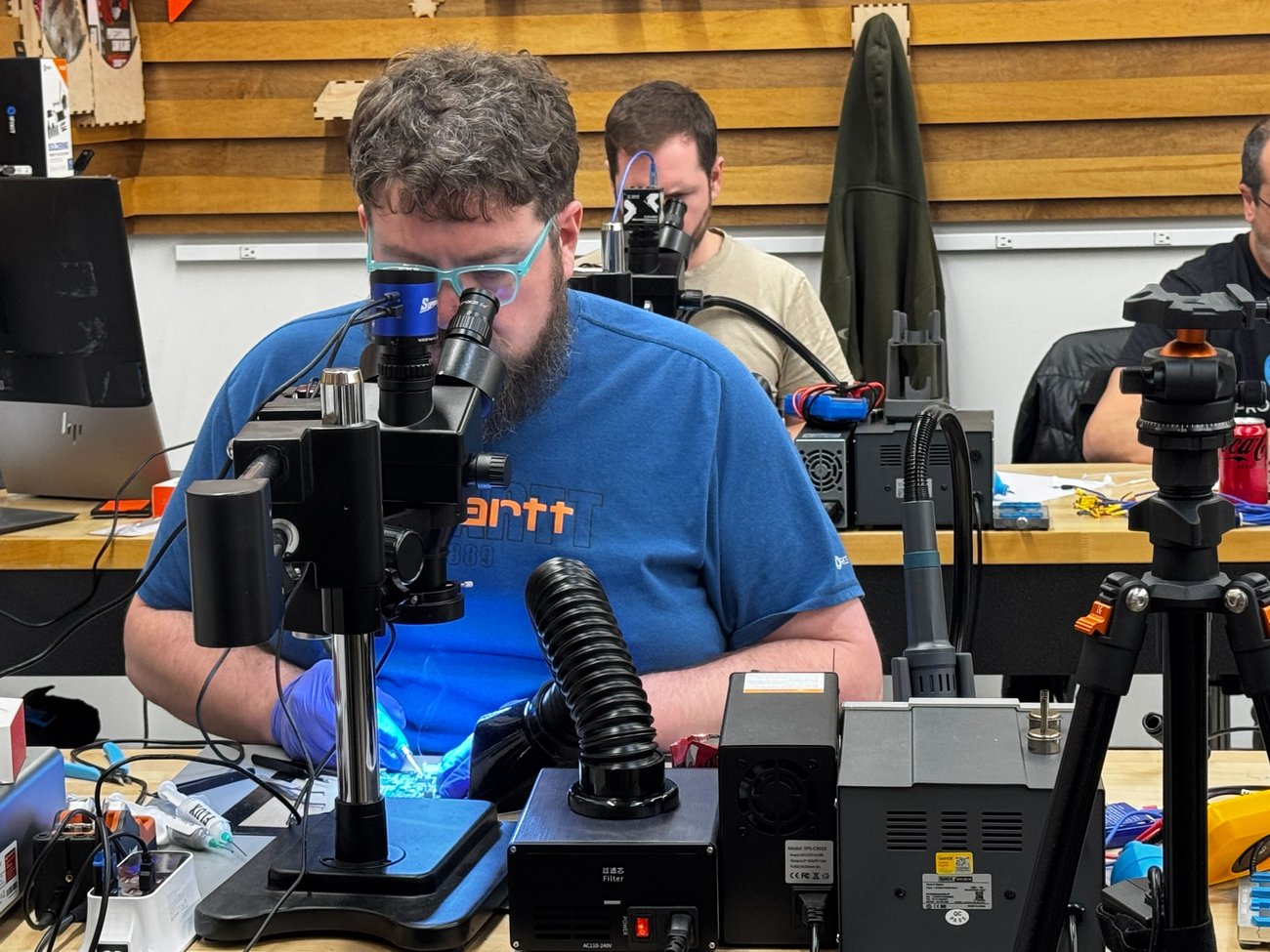 A Microsoldering Academy student looks into a microscope at his board repair