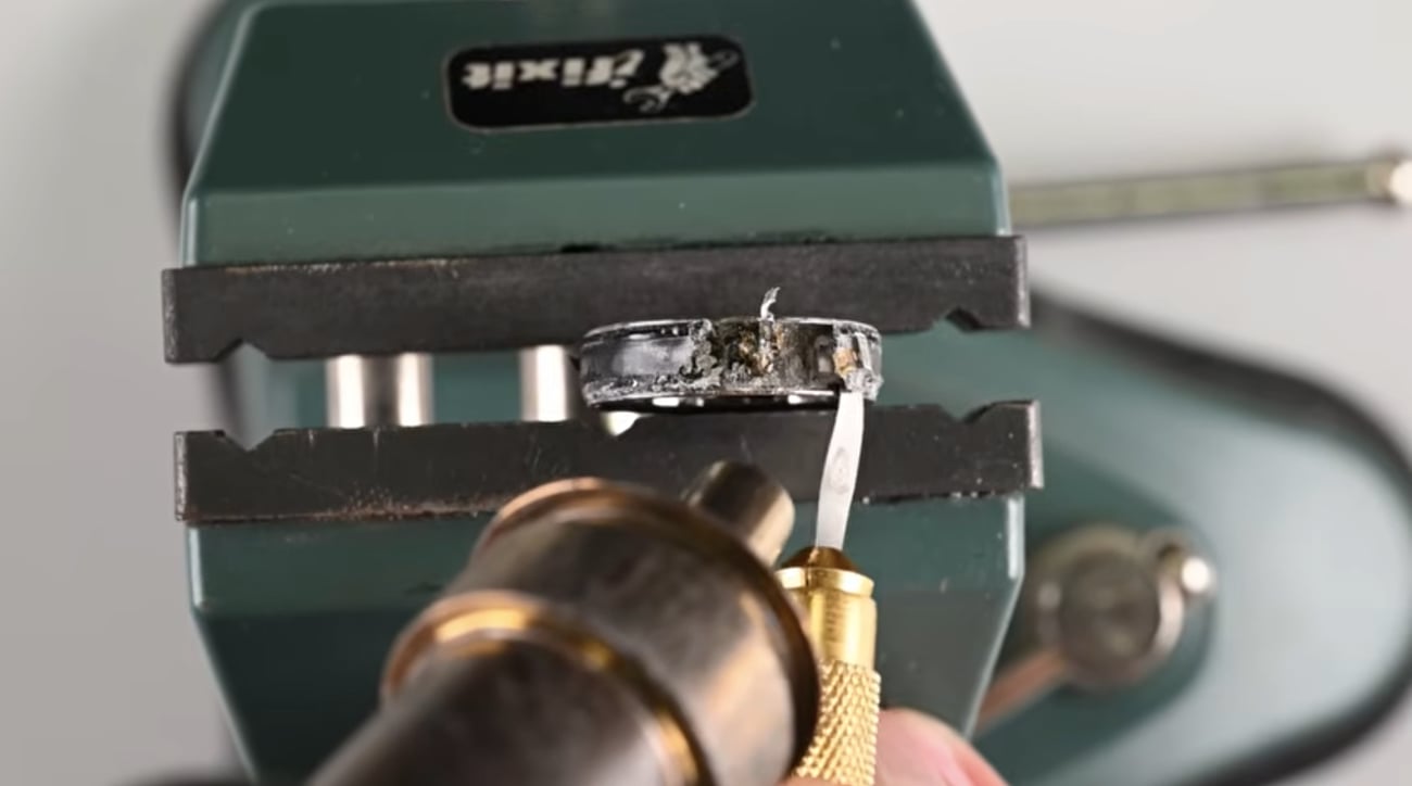 A destroyed Oura Ring 5 sits in our vice as we attempt to disassemble it.