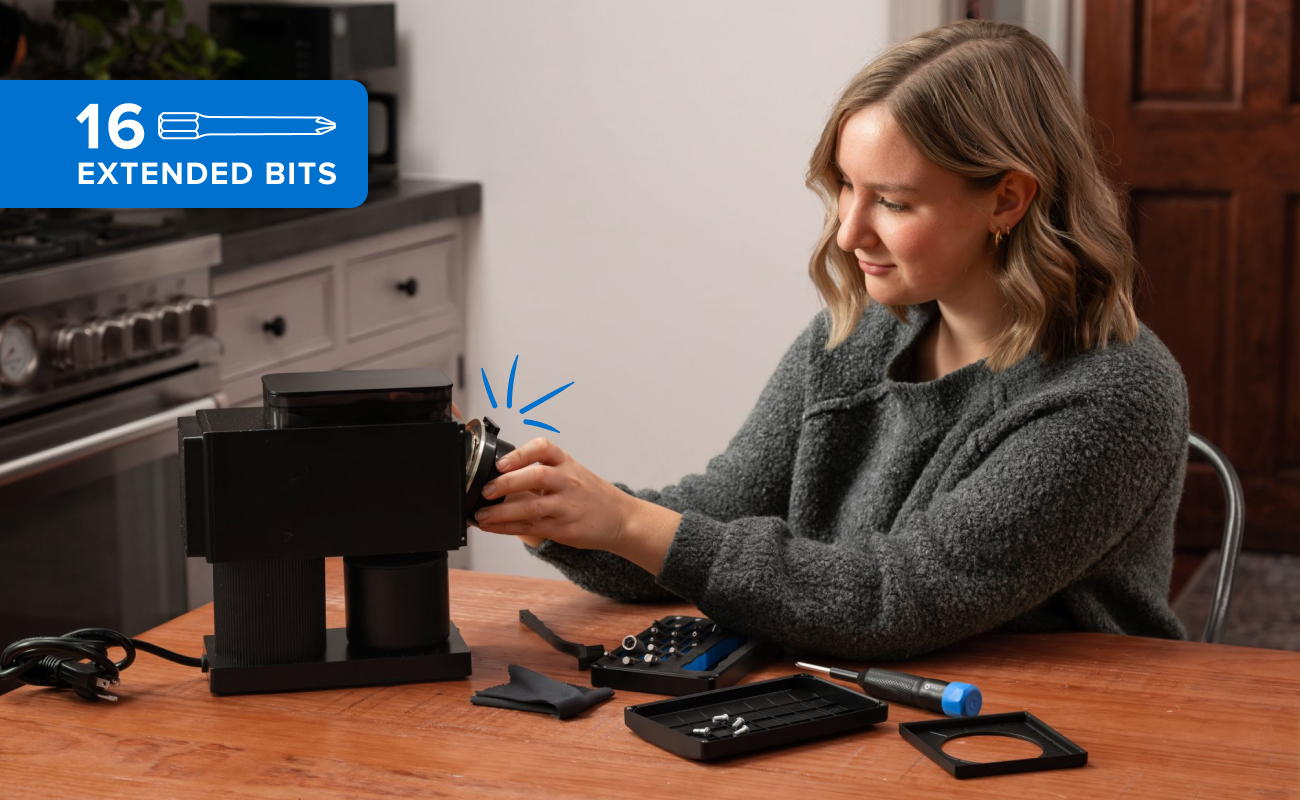 A woman uses the Megalodon Driver Kit to repair her coffee machine