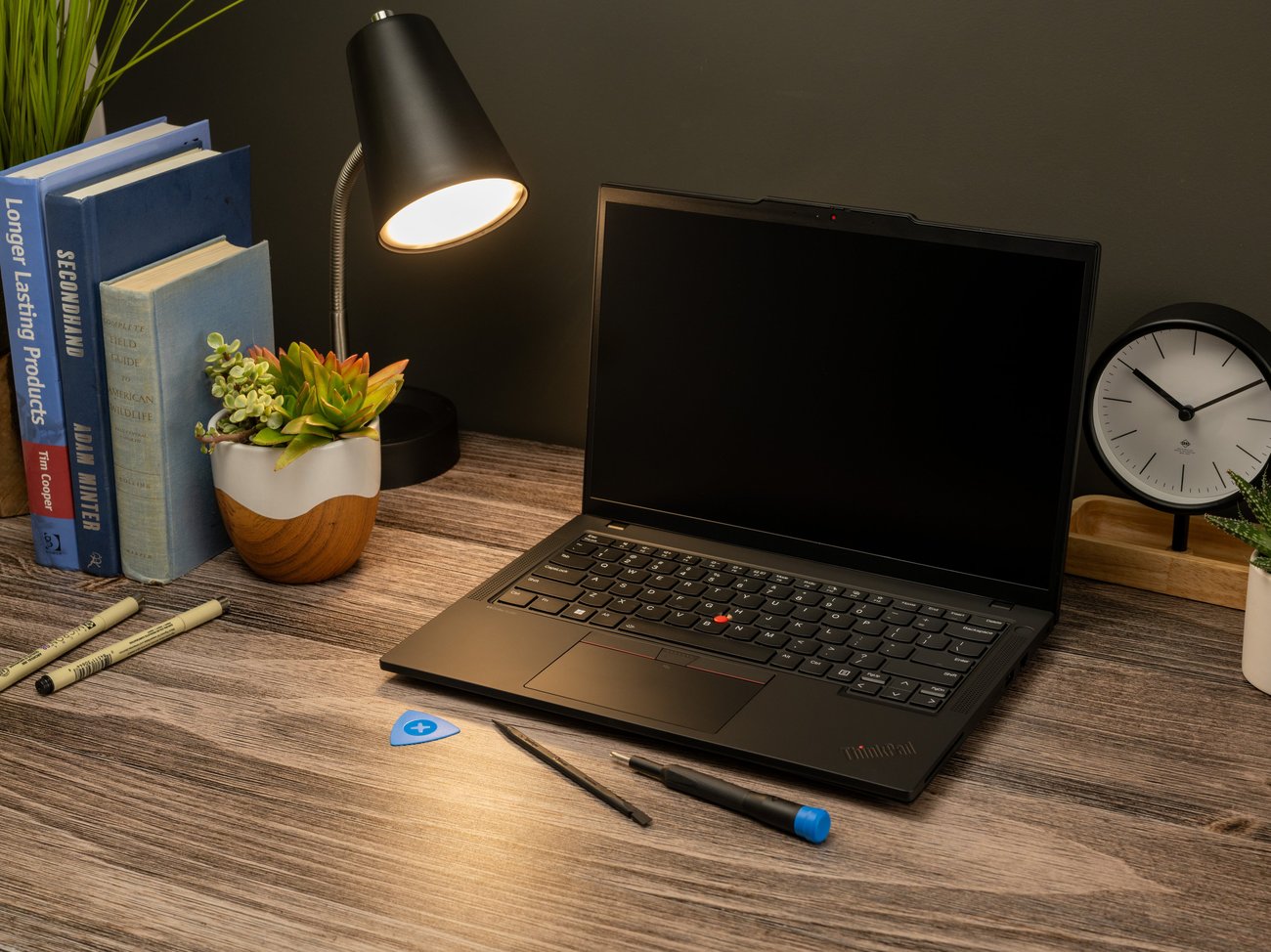 A Logitech laptop sites on a furnished desk with iFixit tools.