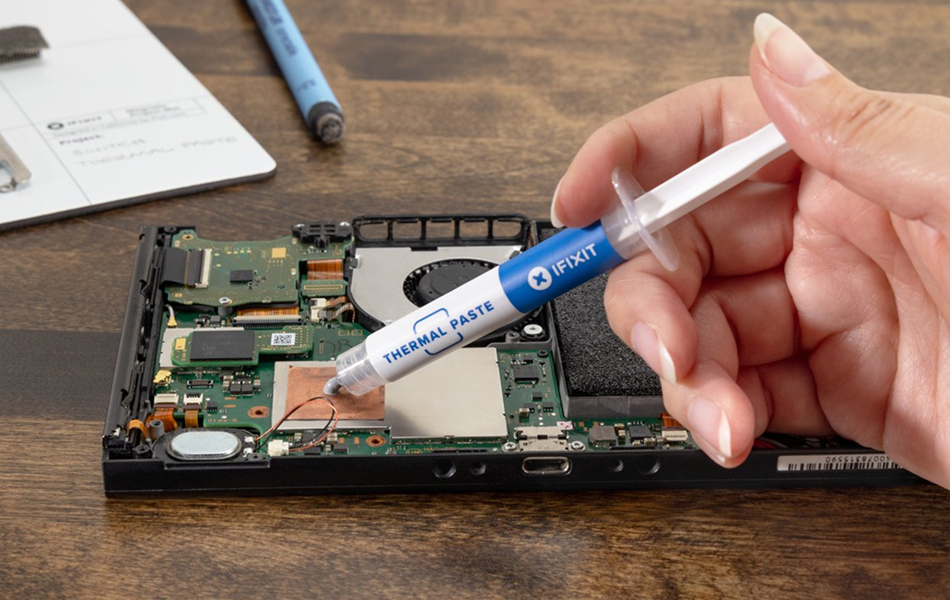 Image of a hand applying thermal paste to a Steam Deck.