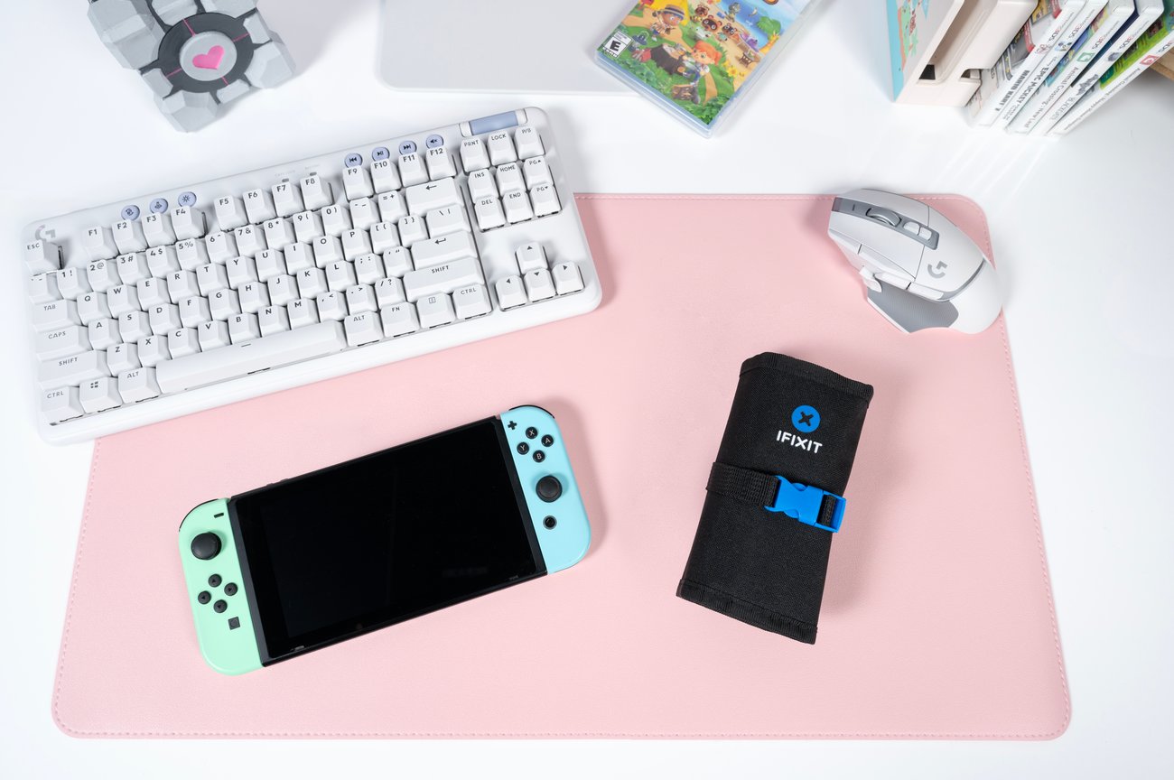 The new Game Console Toolkit pictured on a pink desk mat with a Nintendo Switch, mechanical keyboard, and game cartridge cases.