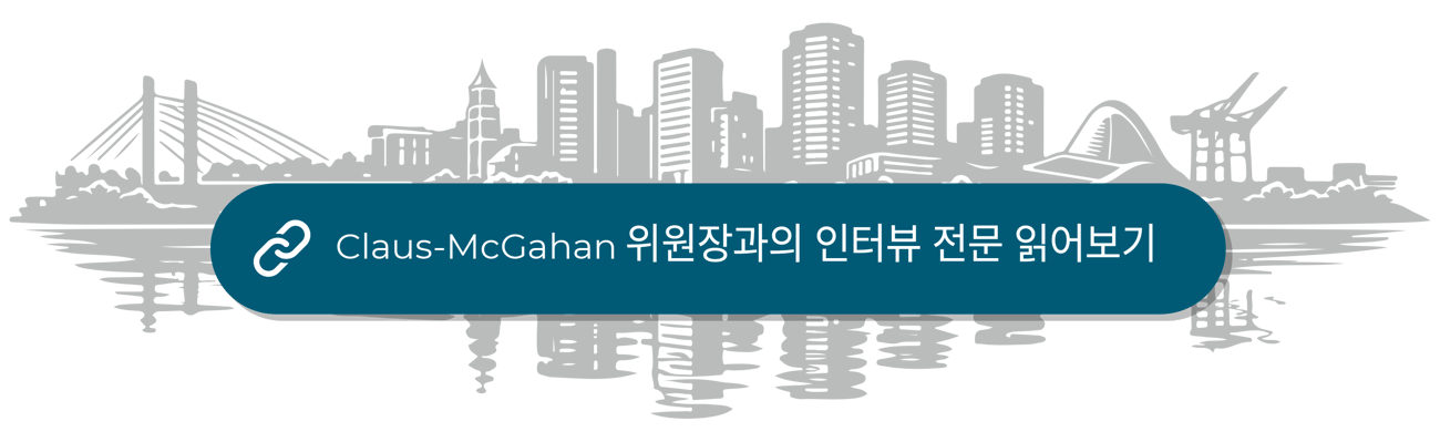 건물과 다리가 보이는 도시의 정형화된 스카이라인. 다음 문구가 덧입혀진 청록색 직사각형: "Claus-McGahan 위원장과의 인터뷰 전문 읽어보기."