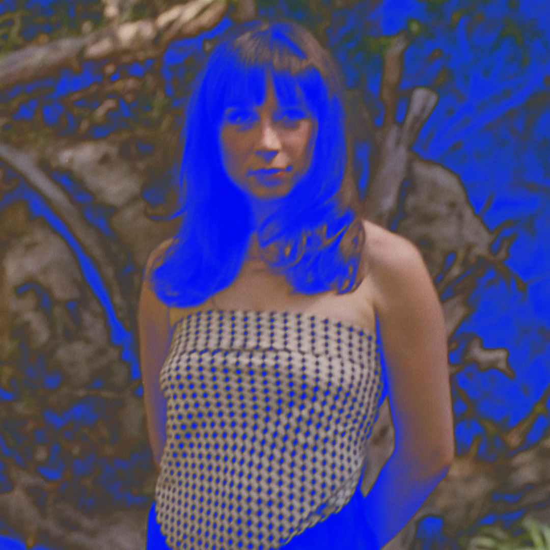 A press shot of DJ Adriana standing in the bush