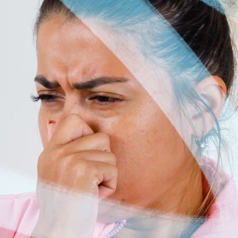 Photo of a woman holding her nose indicating she smelled something bad