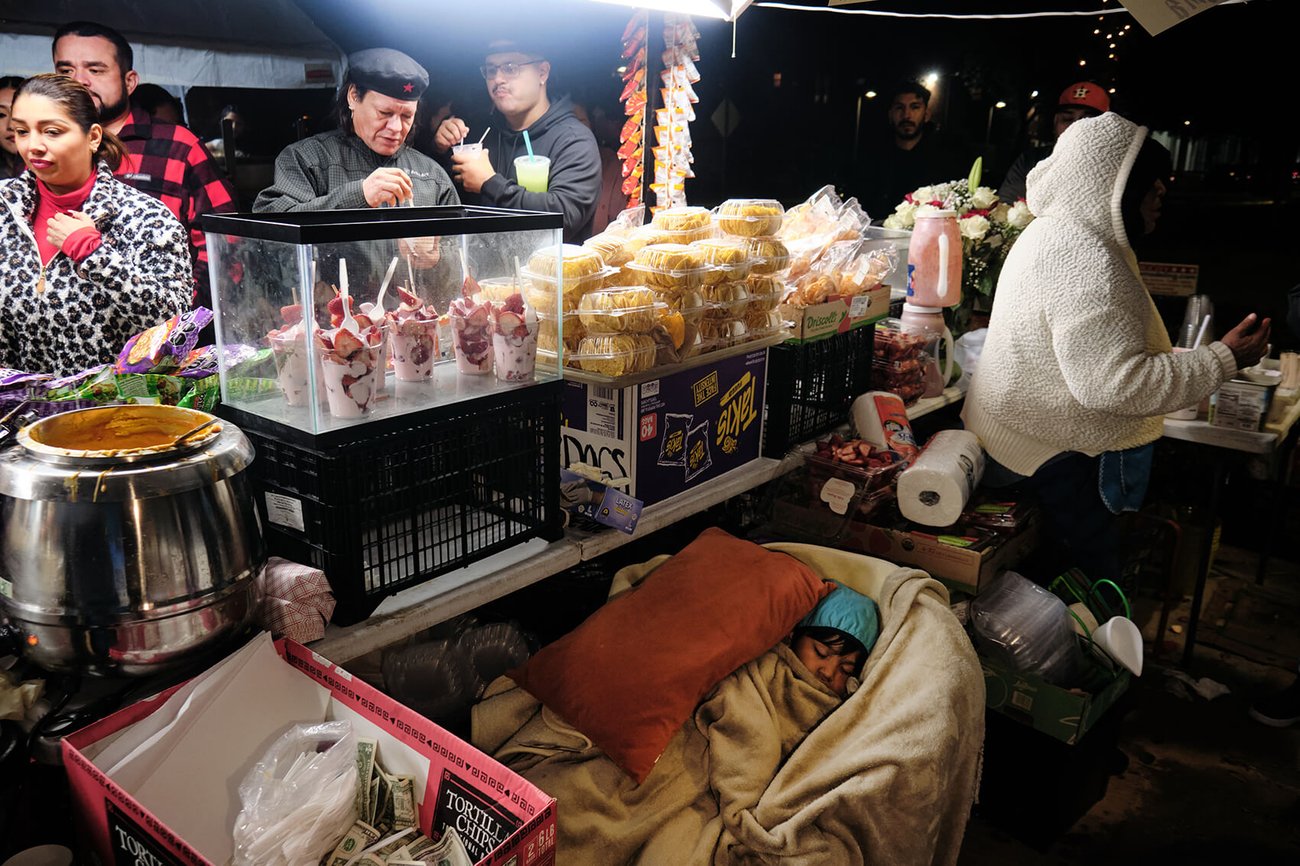 Anthony Padilla (3) sleeps under the table as his family sells food goods at the market on the Esplanade on Navigation during the celebrations for el Dia de la Virgin de Guadalupe on Tuesday, Dec. 12, 2023, in Houston. Anthony Padilla (3) sleeps under the table as his family sells food goods at the market on the Esplanade on Navigation during the celebrations for el Dia de la Virgin de Guadalupe on Tuesday, Dec. 12, 2023, in Houston.