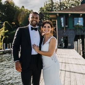 bride and groom pose by lake