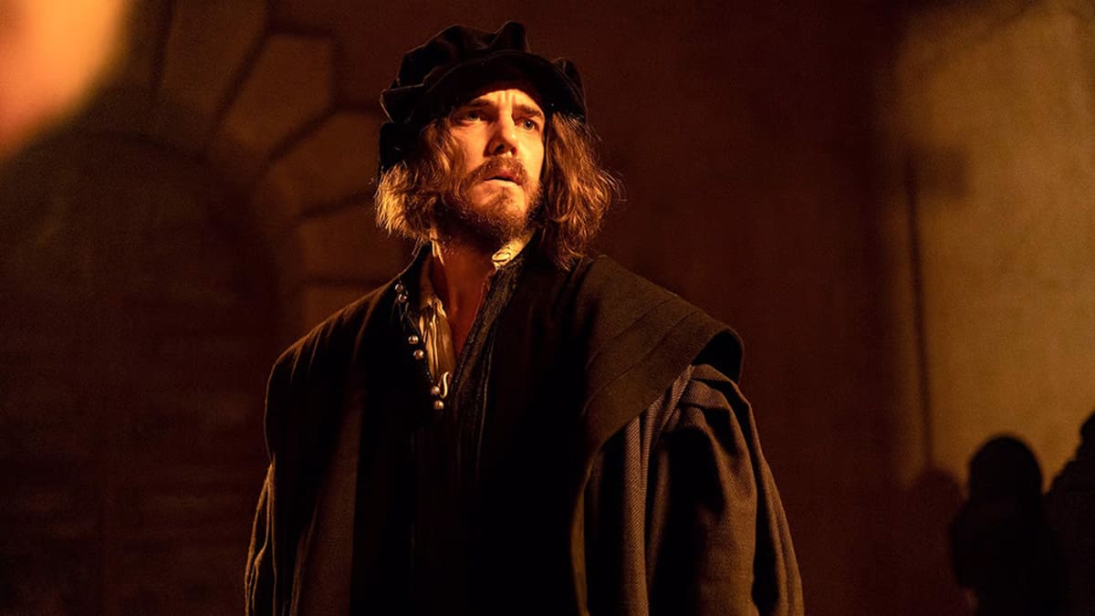 An actor portraying Michaelangelo dressed in a black coat and hat is positioned in a shadowy room, evoking a sense of intrigue and solitude. An actor portraying Michaelangelo dressed in a black coat and hat is positioned in a shadowy room, evoking a sense of intrigue and solitude.