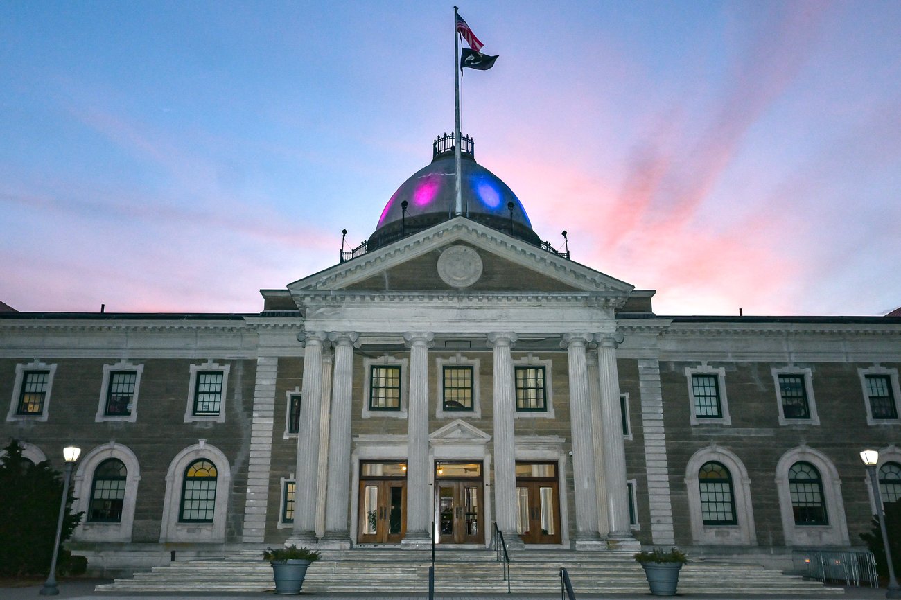Photo of an official building in New York lit up in Rare Disease Day colors