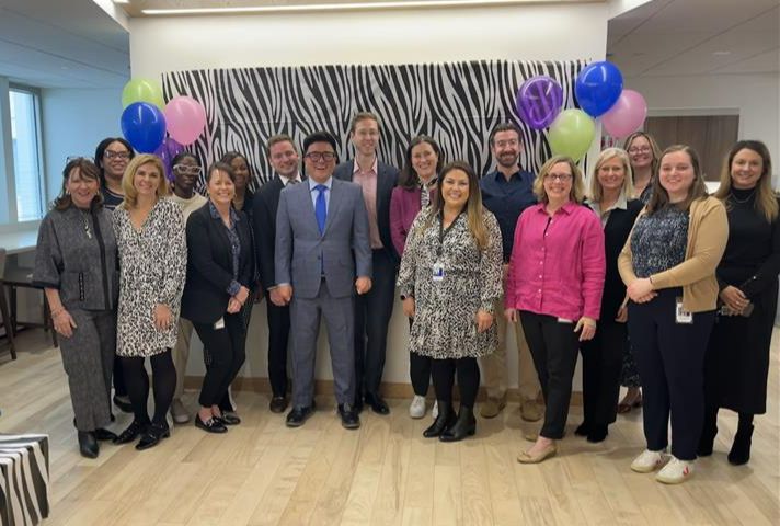 Photo of Amgen staff in front of a zebra print wall with balloons