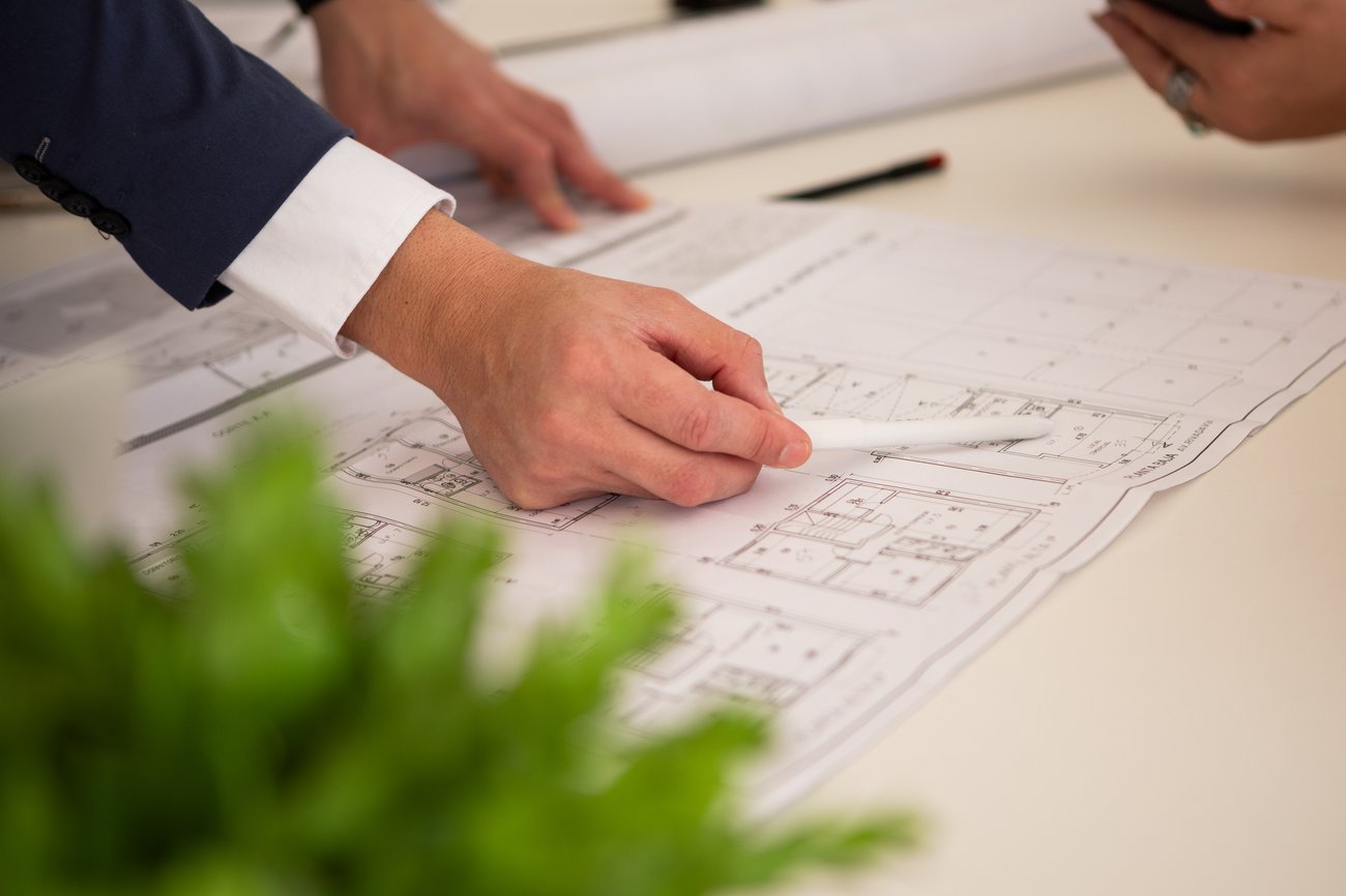 Closeup of male hand pointing at an architectural plan stock photo
