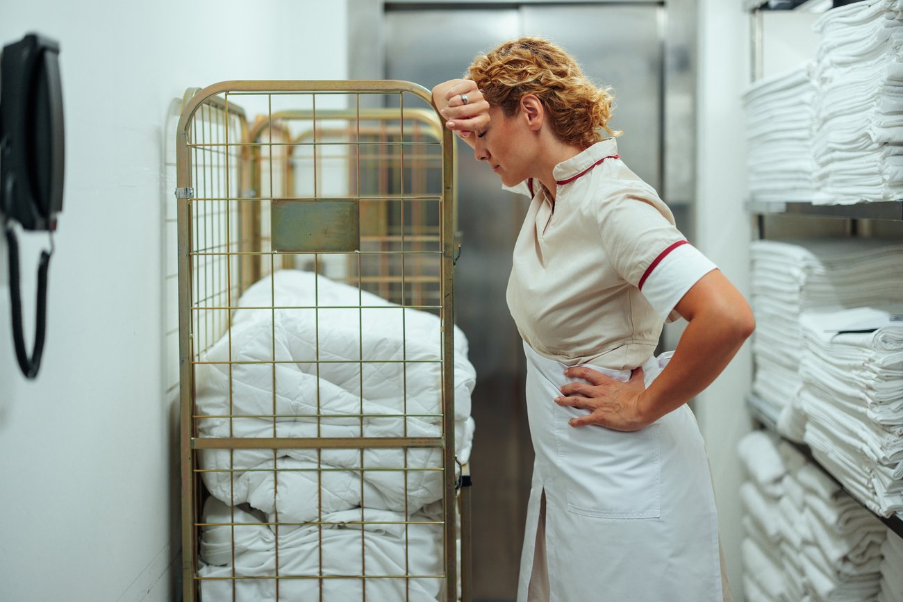 Tired housekeeper resting in laundry area