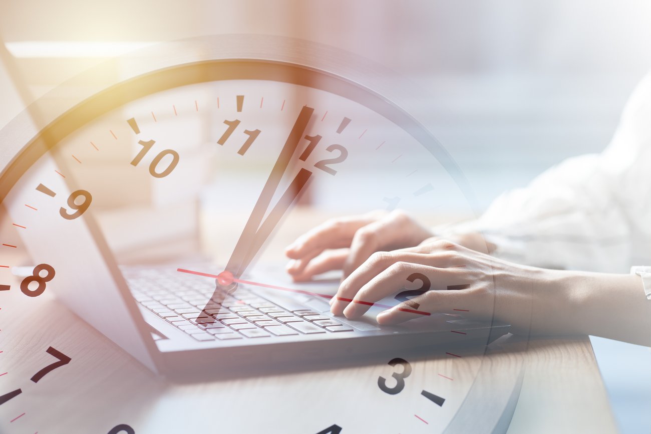 women typing on computer with opaque overlay of clock