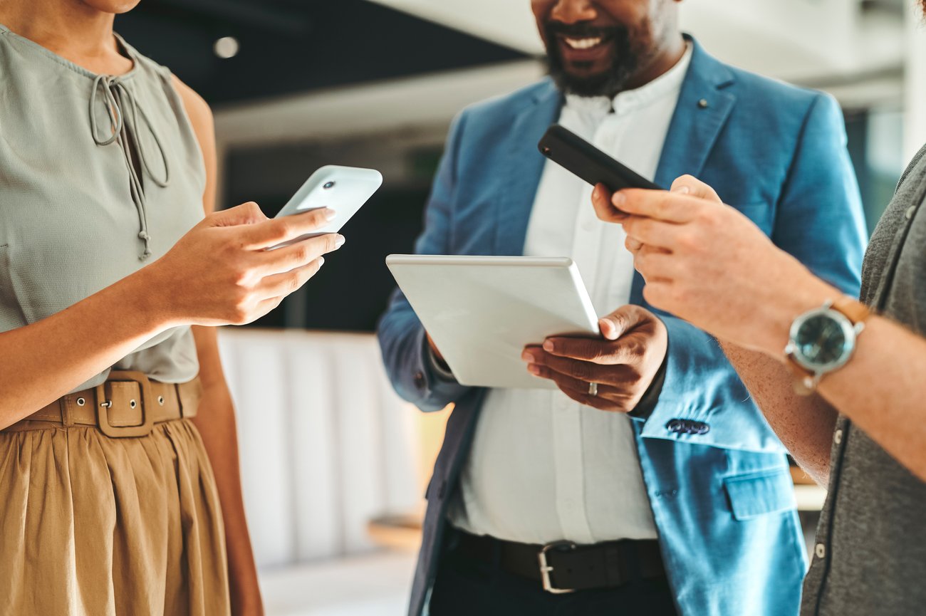 group of business people in a circle, on phones and tablets