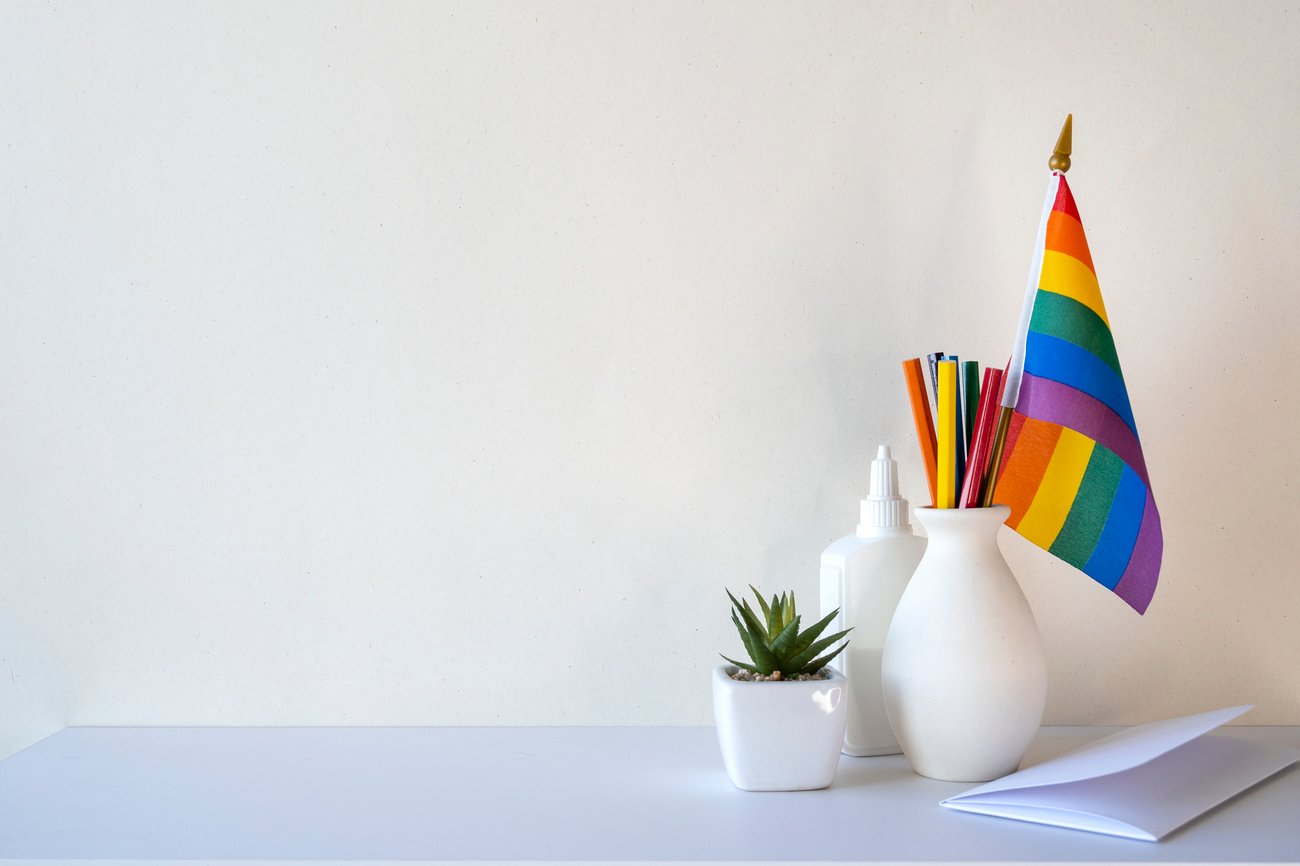 various white office items with a rainbow flag in a pencil organizer