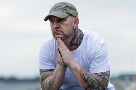 Man sitting down with his hands in a prayer position under his chin