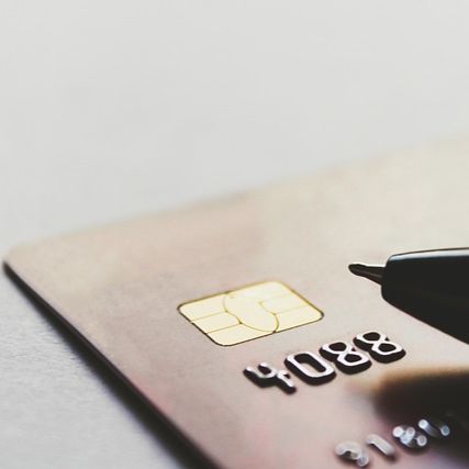 Credit card laying flat with an ink pen next to the card