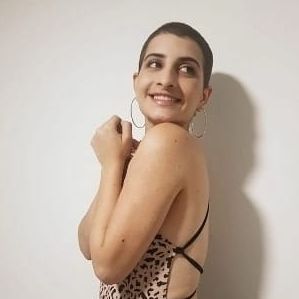 Teen girl wearing a dress and smiling. 