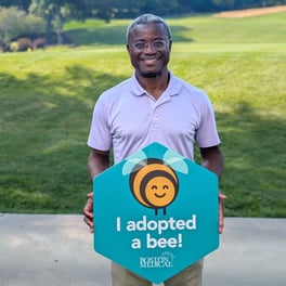 BMC employees pose with “Adopt a Bee” signage 