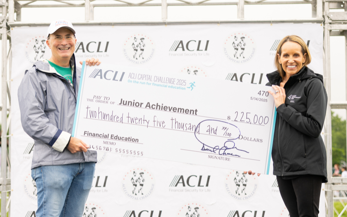 A picture of David Chavern and Catherine Milone holding a $225,000 check to Junior Achievement