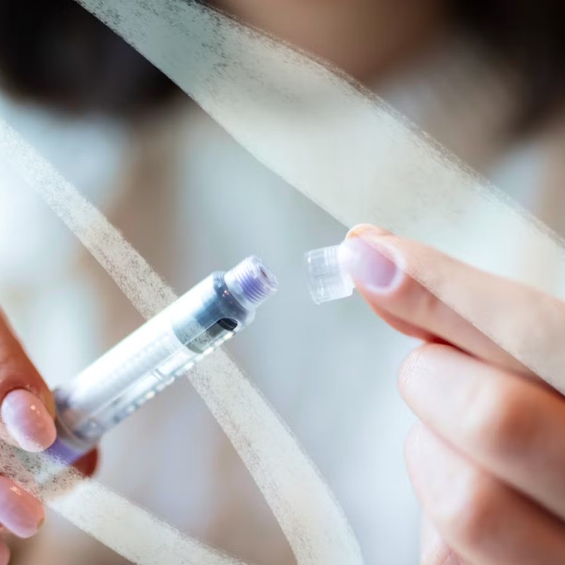 Close up photo of someone putting a cap on a medical instrument