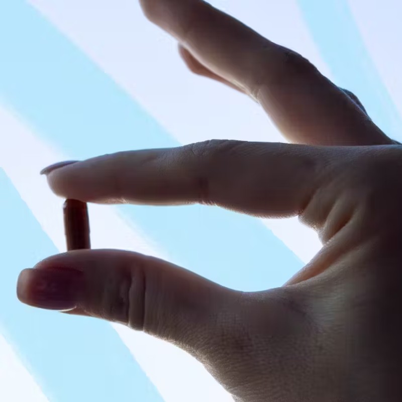 Close up photo of someone holding a pill