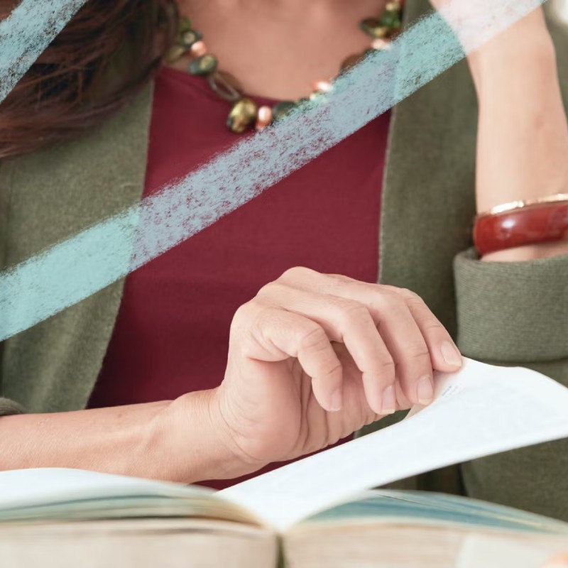 Close up photo of a woman flipping the page of a book