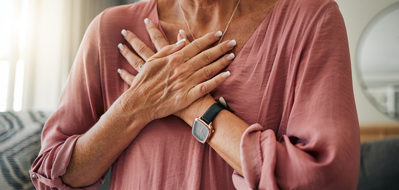 Photo of a woman with her hands clutching her chest