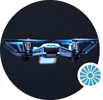 A metallic drone hovering in flight.