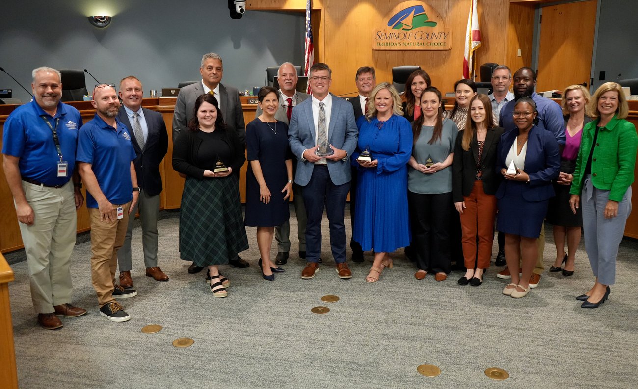 Office of Communications staff standing with County Commission holding awards