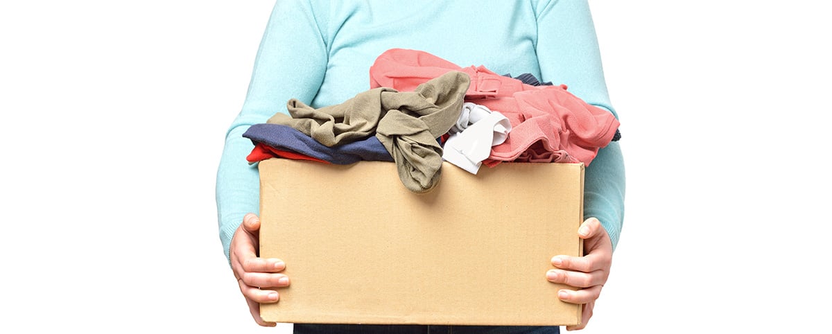 person holding box of used clothes person holding box of used clothes