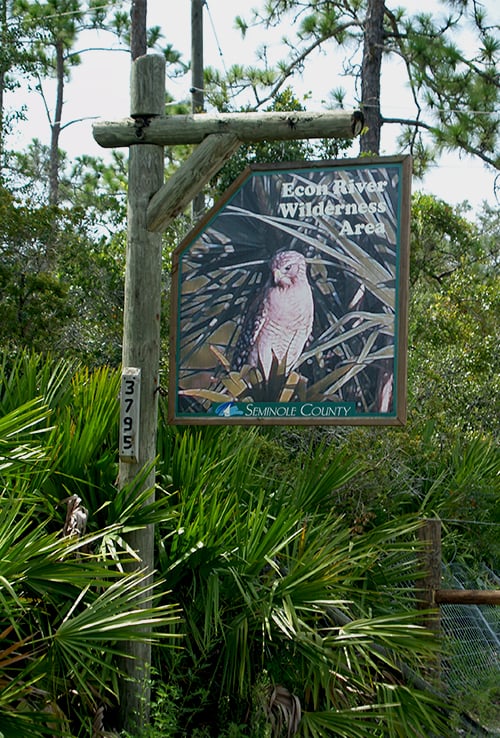 wilderness area sign outside park entrance among plants