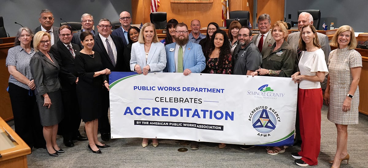 Public works holding banner with county commission for accreditation Public works holding banner with county commission for accreditation