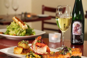 wine bottles, glass of wine, and food on tables
